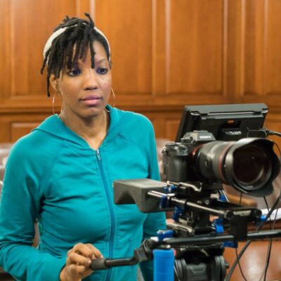 Film Director Brandi Webb behind the camera filming her documentary Betrayal of a Nation inside of a Bronx courthouse